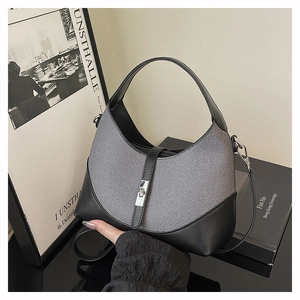 Detail of grey-black Hobo bag with textured fabric, silver metal buckle, and strap