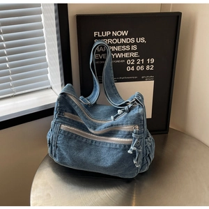 Close-up of retro blue washed denim tote bag with three functional layered zippers