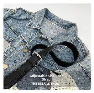 Detail of adjustable black faux leather shoulder strap with a silver metal buckle