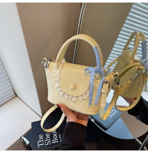 Détail du mini sac seau jaune avec bordure en dentelle et ruban à carreaux bleus