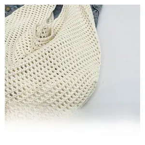 Detail showing the intricate white crochet texture of this large knit beach shoulder bag
