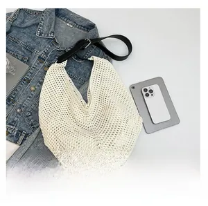 Close-up of cream crochet knit shoulder bag with black adjustable leather strap