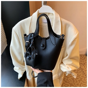 Detail of black lychee grain bucket bag featuring matching mini pouch and metal D-ring