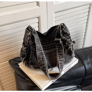Detailed macro view of retro washed denim texture and functional zippers on the shoulder bag