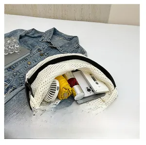 Detail showing high-capacity interior of white knit tote bag with beach essentials