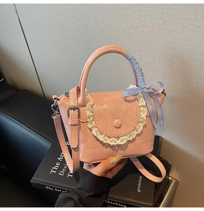 Sac seau plissé rose avec dentelle blanche et nœud à carreaux bleus en gros plan