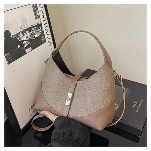 Close-up of beige contrast handbag featuring silver twist lock and woven fabric texture