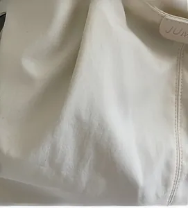 Detail of high-quality canvas fabric with neat stitching and minimalist logo tag
