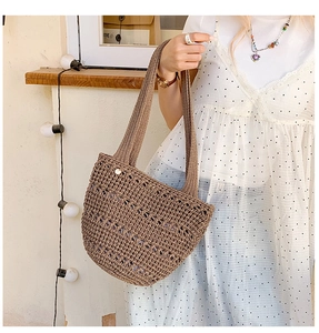 Detailed macro view of the dark brown hand-woven hollow texture on a summer tote bag