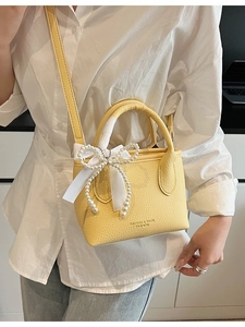 Yellow litchi pattern leather mini bucket bag with pearl bow and silk ribbon detail
