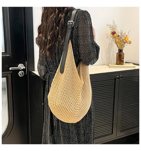 Detail of bohemian crochet tote with adjustable black leather strap and hollow weave