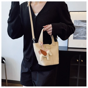 Detail of a beige pebbled leather bucket bag featuring a horse charm and versatile straps