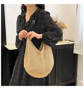 Detail of beige crochet tote bag featuring adjustable black leather strap and metal buckle