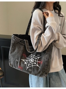 Gothic denim tote bag featuring white spider web embroidery and spacious shoulder design