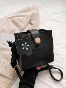 Stylish black leather bucket bag with wooden buckle and decorative floral charm