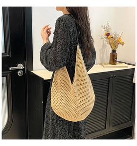 Detail of beige hollow woven shoulder bag with floral patterns on a female model