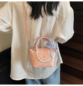 Détail du sac seau en cuir PU rose avec dentelle et nœud à carreaux bleu sur mannequin