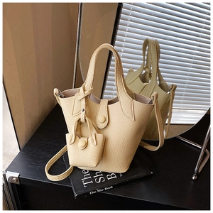 Detailed view of yellow bucket bag with mini coin purse on a display stand