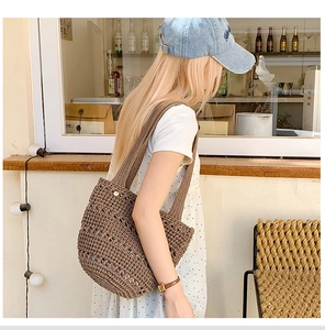 Detail of dark brown crochet tote bag with intricate hollow woven texture and wide shoulder strap