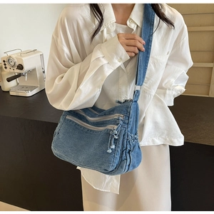 Detail view of the durable washed denim material and side drawstring pocket of the tote bag