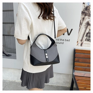 Fashionable grey woven and black leather contrast crossbody bag worn with casual outfit