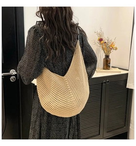 Detailed back view of a hand-knitted beige crochet shoulder bag worn by a model