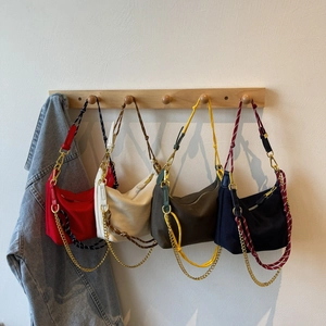 Detail view of nylon crescent bags in four colors with woven rope and gold chain straps