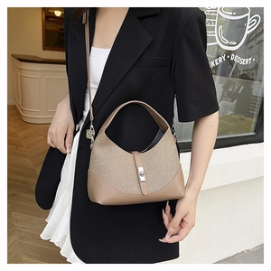 Detail of contrast stitch handbag with silver buckle and leather trim on canvas