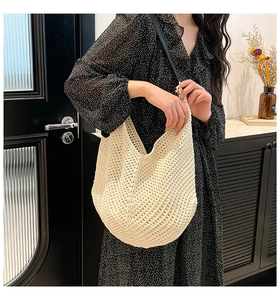 Detail of hollow crochet knit tote bag with black strap for summer casual beach style