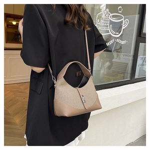 Detail of a beige and brown woven leather handbag with a sleek silver metal buckle lock