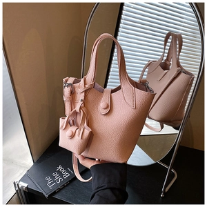 Pink lychee grain leather bucket bag detail with matching mini pouch and elegant mirror view