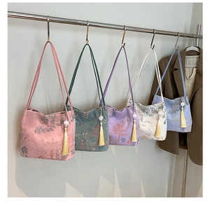 Detail view of five assorted Chinese embroidery bucket bags with silk tassels and landscape patterns