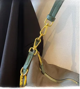 Detailed close-up of the durable gold metal hook on the grey nylon shoulder bag strap