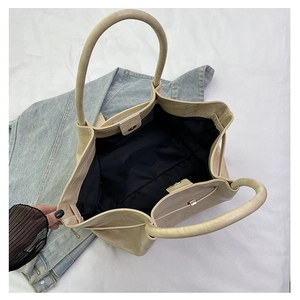 Detail van grote beige shopper met krokodillenreliëf en handige magneetsluiting