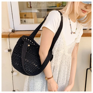 Detail shot of black handcrafted crochet shoulder bag with openwork knit texture