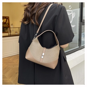 Detail of contrast stitch handbag featuring woven fabric texture and silver rotary clasp
