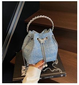 Detail of light blue glitter bucket bag with rhinestone ring handle and pearl tassel charms