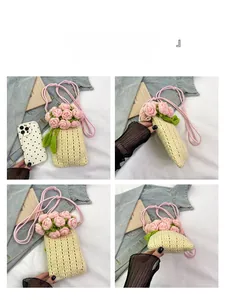 Detail view of handmade knit phone bag with pink crochet roses and cream texture