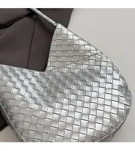 Gros plan sur la texture en cuir tressé argenté et les détails souples du sac hobo chic