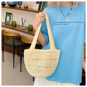 Detail of cream handmade crochet tote bag featuring woven hollow mesh and dual handles