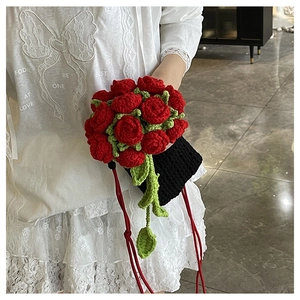 Detailed close-up of handmade crochet red rose bucket bag with green leaves and black knit base