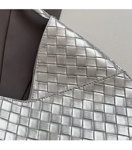 Détail en gros plan de la texture en cuir tressé argenté et coutures fines du sac à main