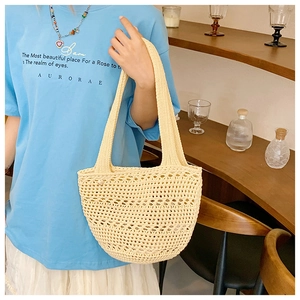 Detail of handwoven hollow mesh texture on a cream white summer straw tote beach bag