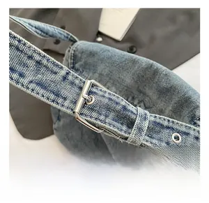 Dettaglio della tracolla regolabile in denim con fibbia argentata sulla borsa