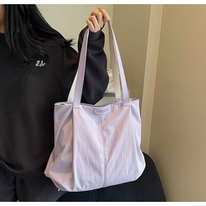 Detail of light purple large canvas tote bag with contrast black hoodie on a person