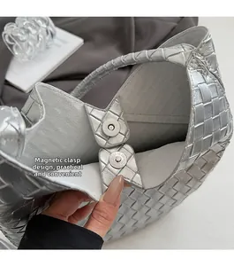 Détail du sac tressé argenté avec un fermoir magnétique métallique pour plus de commodité