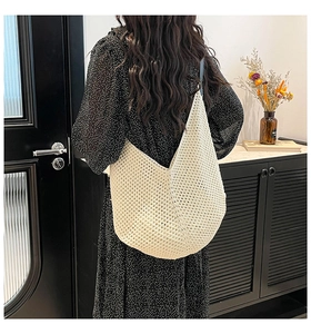 Detailed close-up of ivory crochet shoulder bag with intricate hollow-out knit patterns
