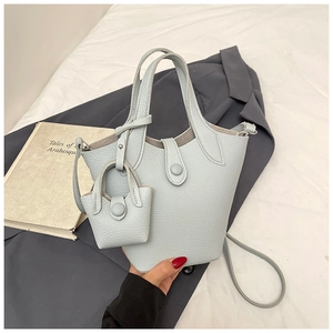 Detailed macro view of light blue lychee-textured leather bucket bag with silver hardware
