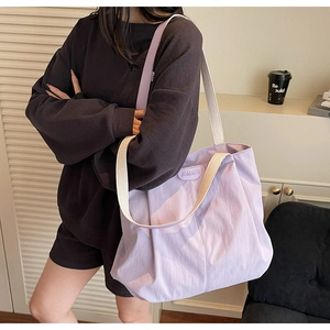 Detail of lavender canvas tote bag with JUMAITU logo and cream woven shoulder strap