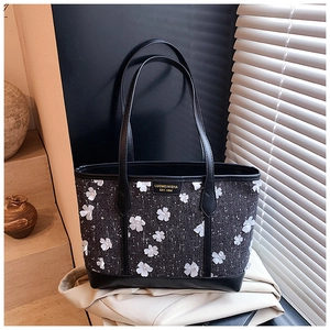 Detail of tweed tote bag with 3D white flower appliqués and elegant pearl centers